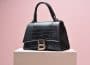Black Leather Handbag on White Wooden Table