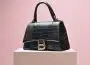 Black Leather Handbag on White Wooden Table