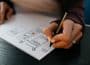 person writing on white paper